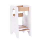 A children's kitchen tower, also known as a kitchen helper stool, designed to allow a child to reach kitchen surfaces safely. The stool has a white frame with natural wood steps and rails, standing on a white background.